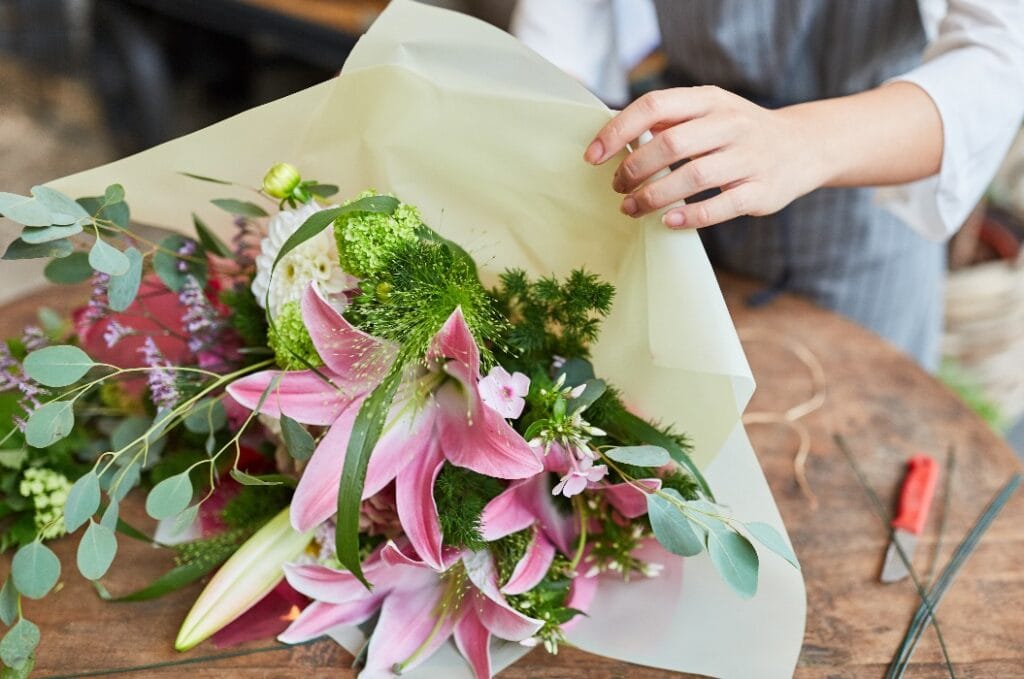 Florist beim Einwickeln von Blumenstrauß in Papier